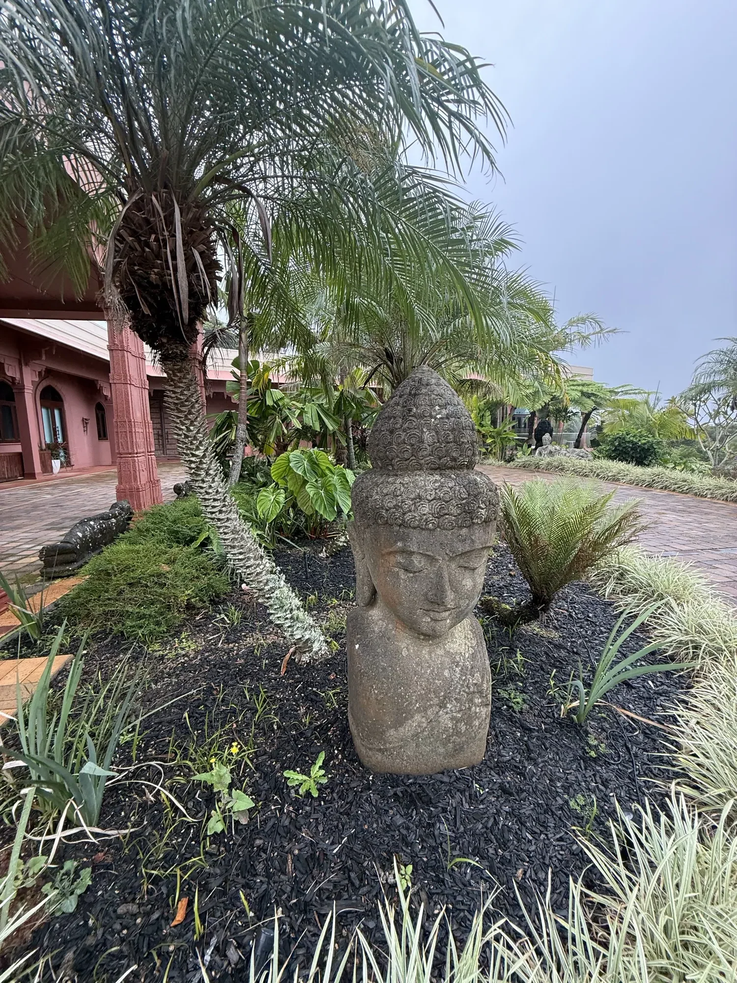 The gardens at Jodha Bai, a stone Buddha bust beside the garden path