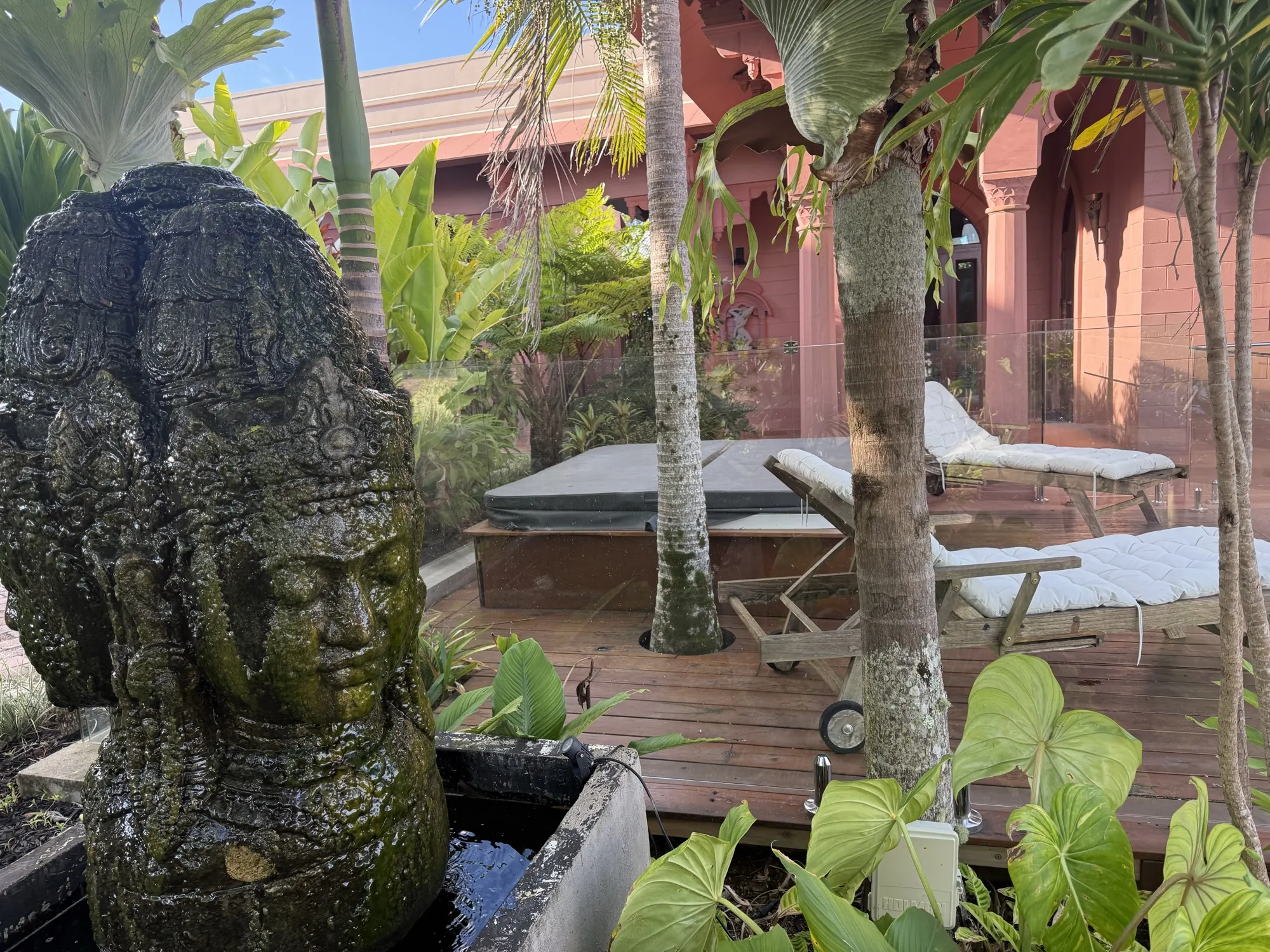 The gardens at Jodha Bai, a carved stone fountain beside the spa deck and sun loungers