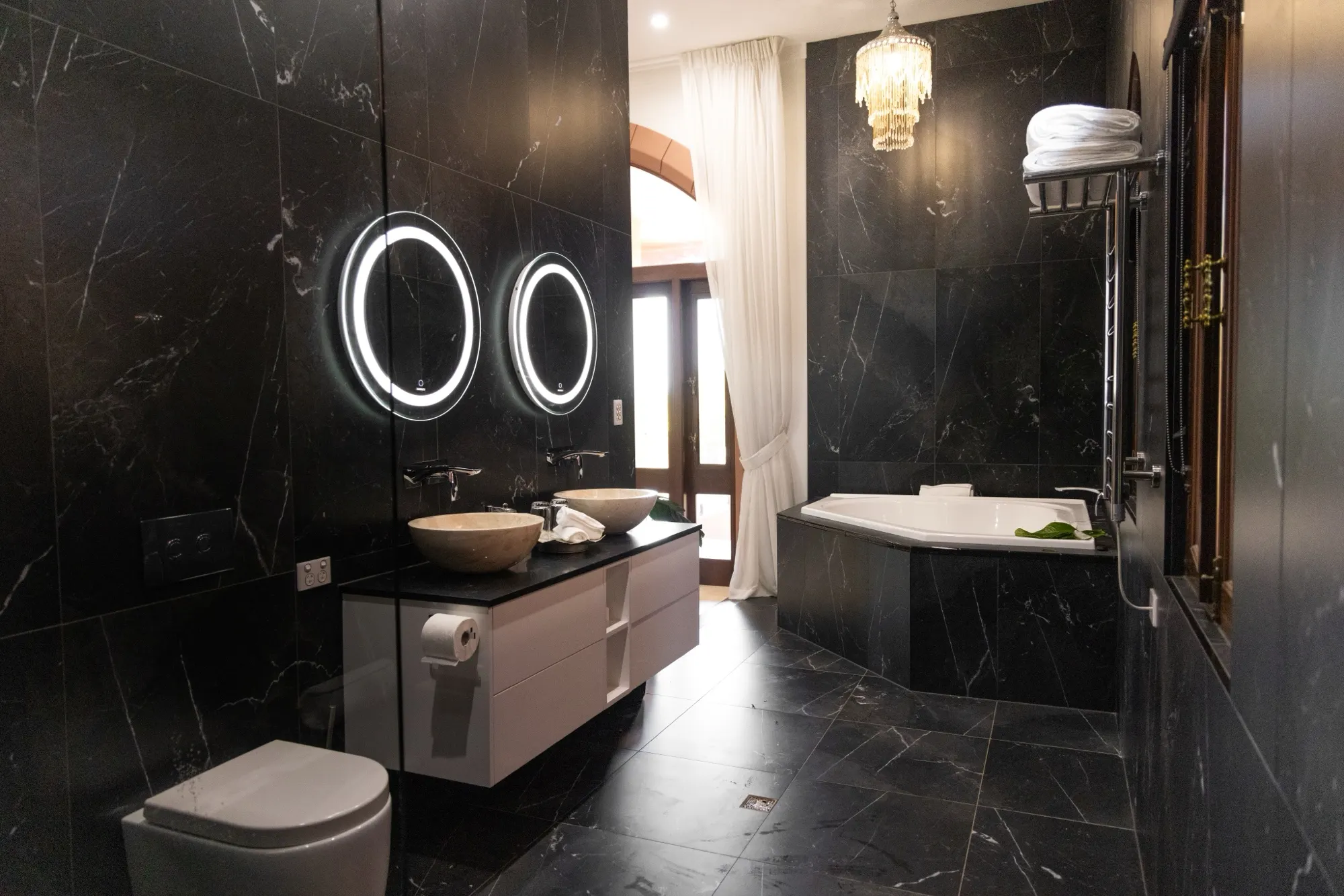 The Jodha Bai Suite, twin stone basins and a freestanding bath beneath a chandelier