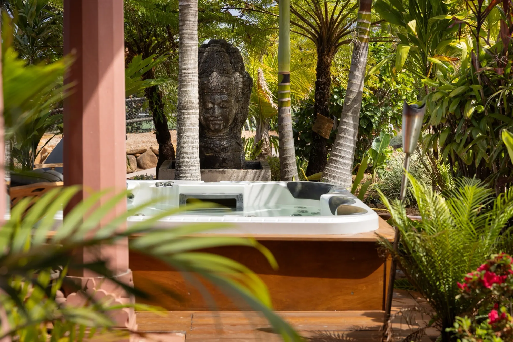 The Jodha Bai Suite, the outdoor spa surrounded by palms and a carved stone statue