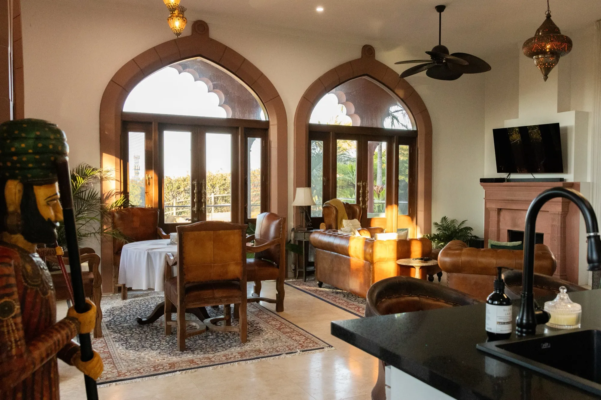 The Jodha Bai Suite, leather armchairs and the dining table beneath arched glass doors