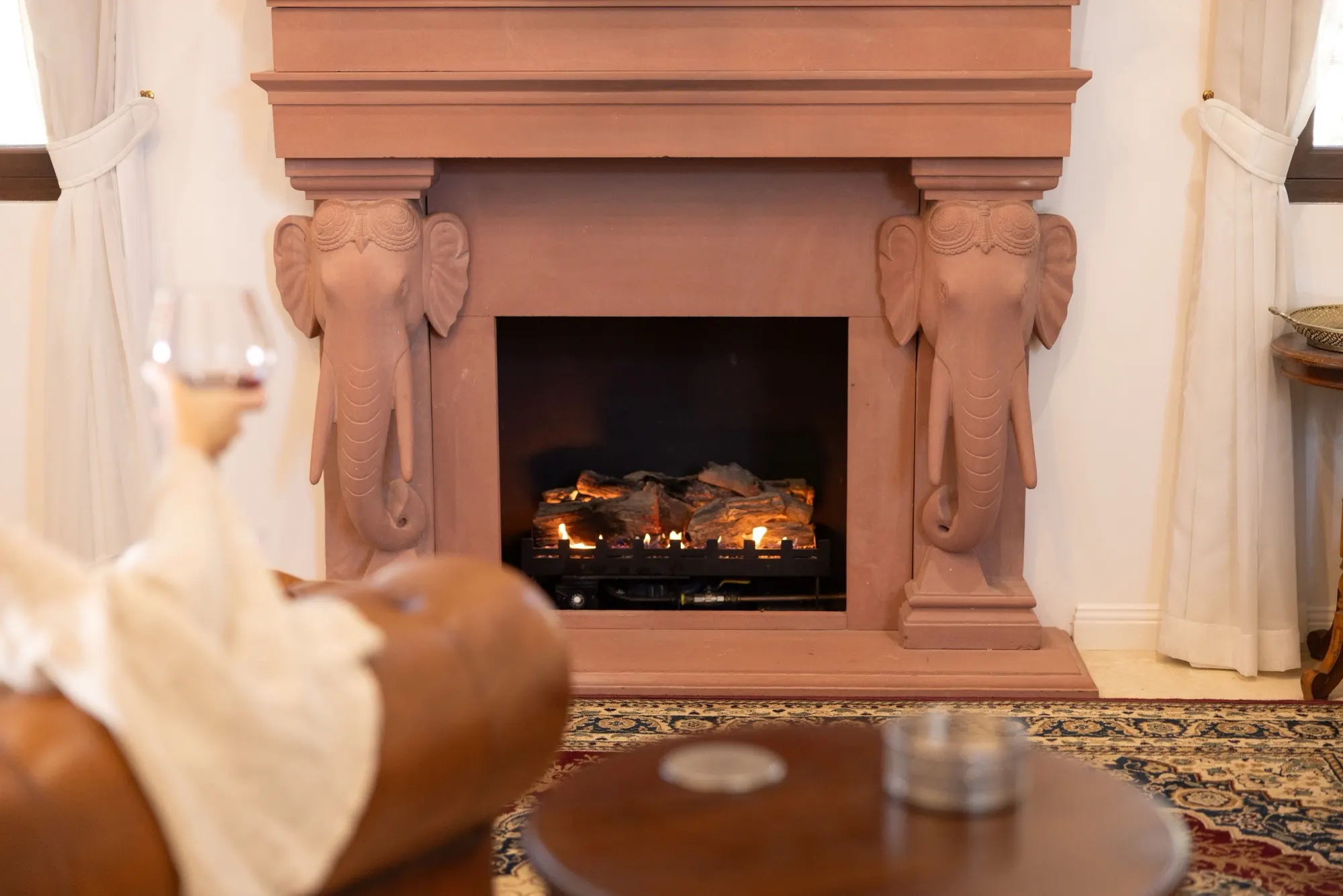 The Lotus House, a sandstone fireplace with carved elephant head corbels