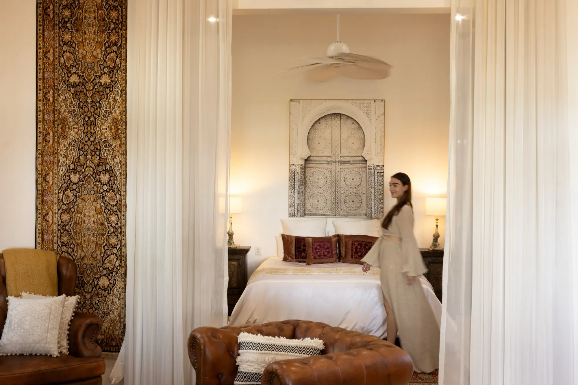 The Lotus House, the bedroom with sheer curtains and a Moroccan door artwork above the bed