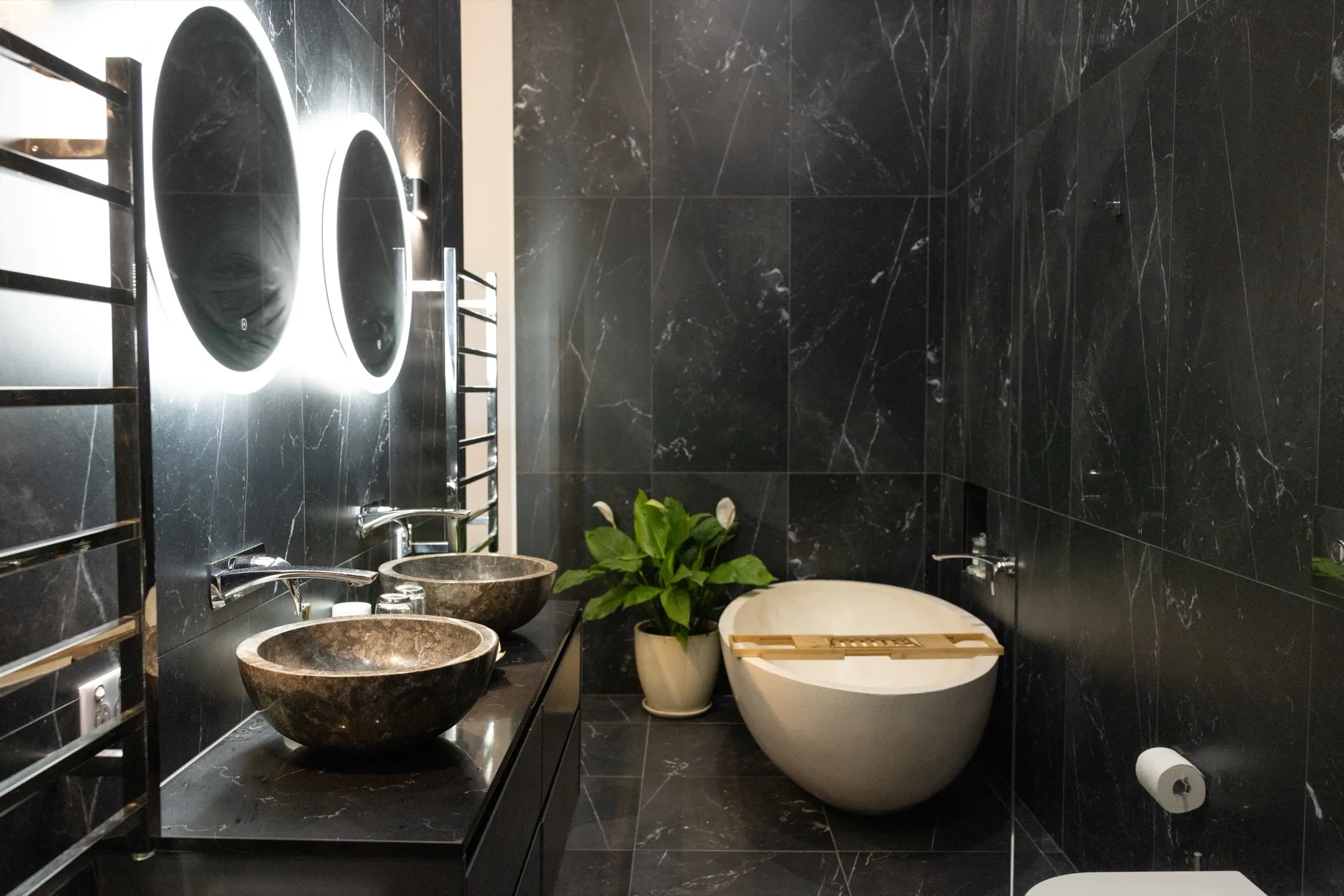 The Lotus House, twin stone basins and a freestanding bath in the black marble bathroom