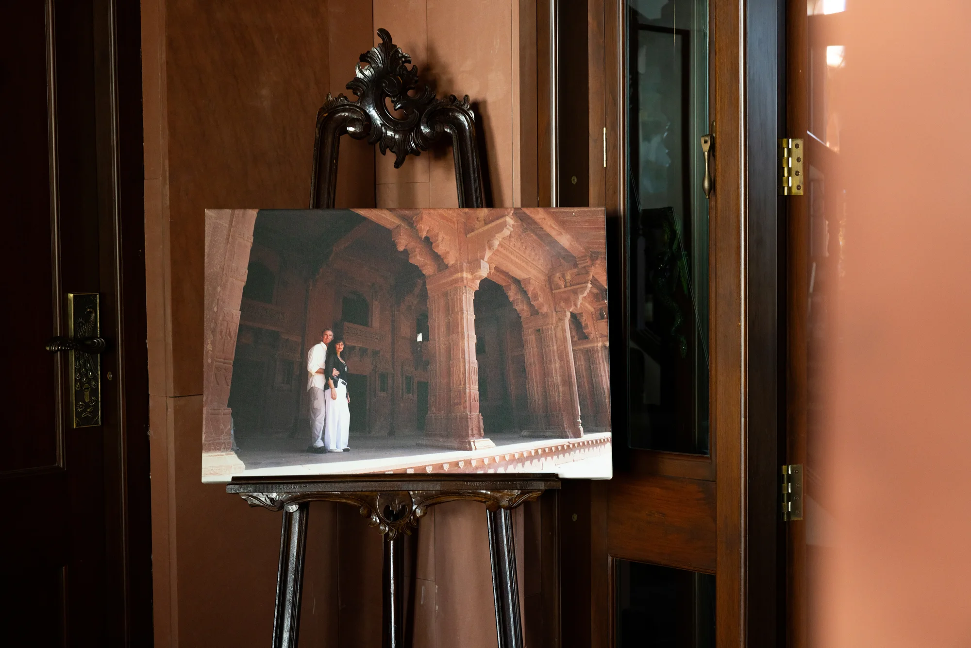A framed photo of Cliff and Susan at the original Jodha Bai palace in India, displayed on an easel