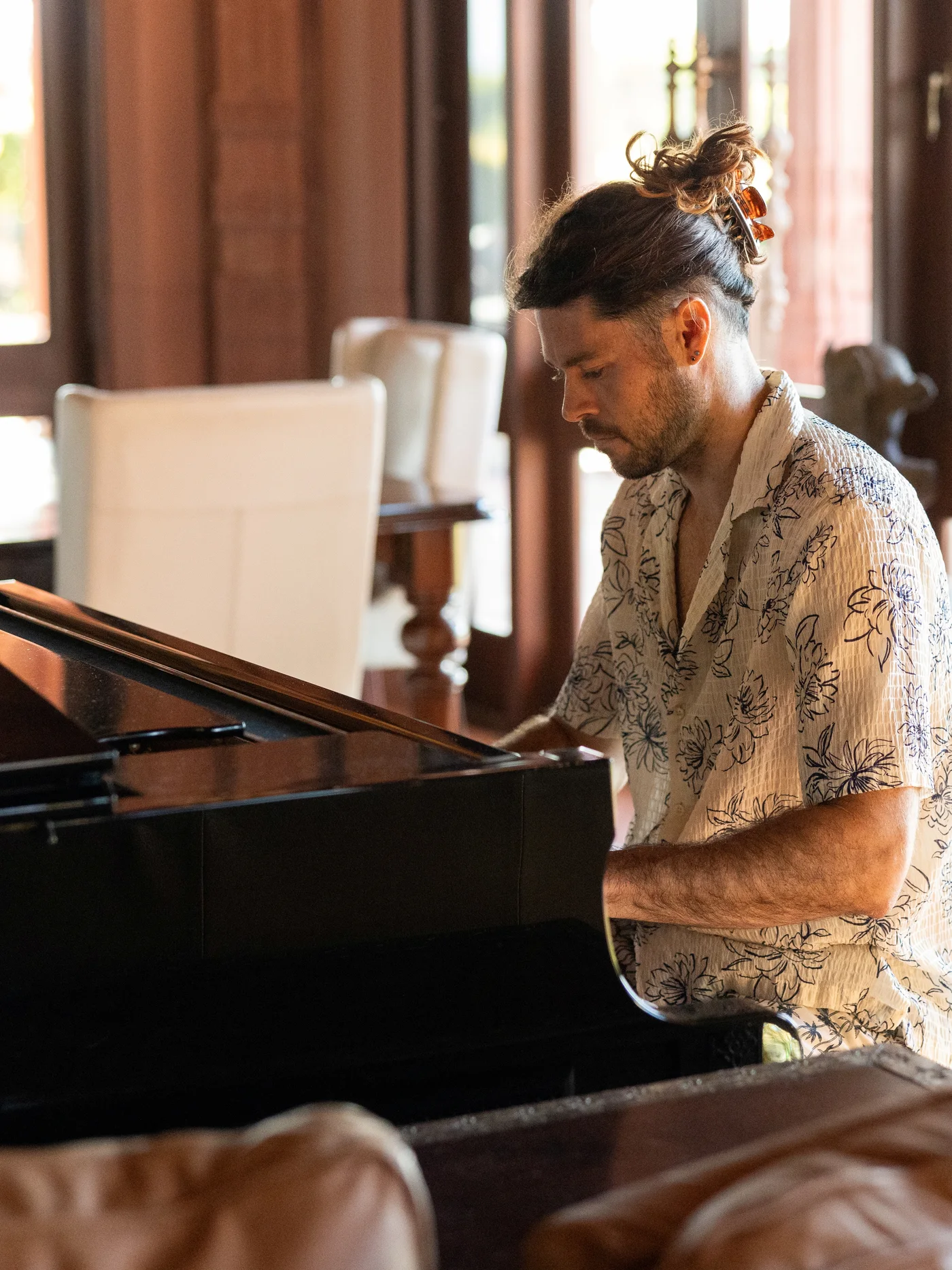 A model at the grand piano inside the palace living room